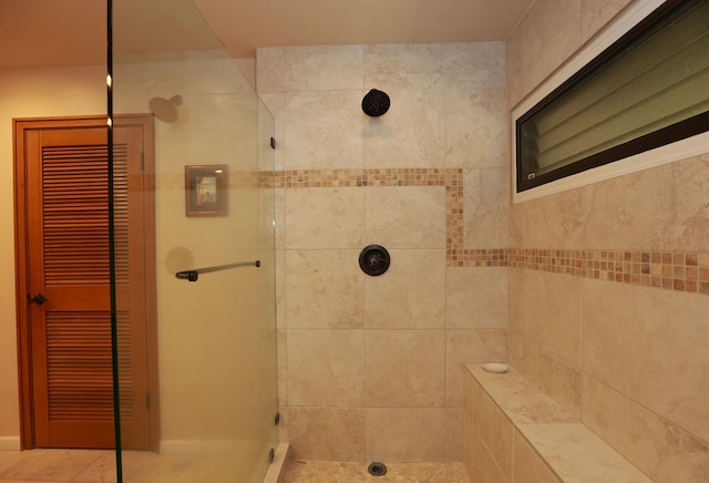 bathroom with a closet and a tile shower