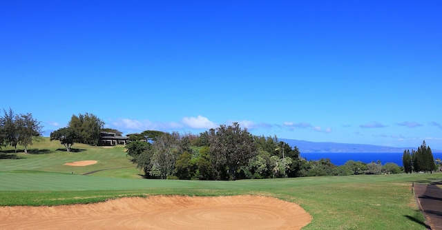 surrounding community with view of golf course, a mountain view, and a yard