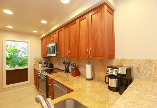 kitchen with stainless steel appliances, recessed lighting, backsplash, brown cabinetry, and light stone countertops