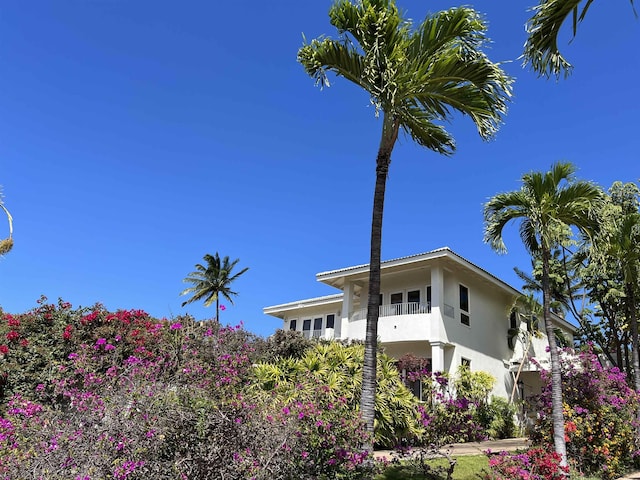 view of side of home with stucco siding and a balcony