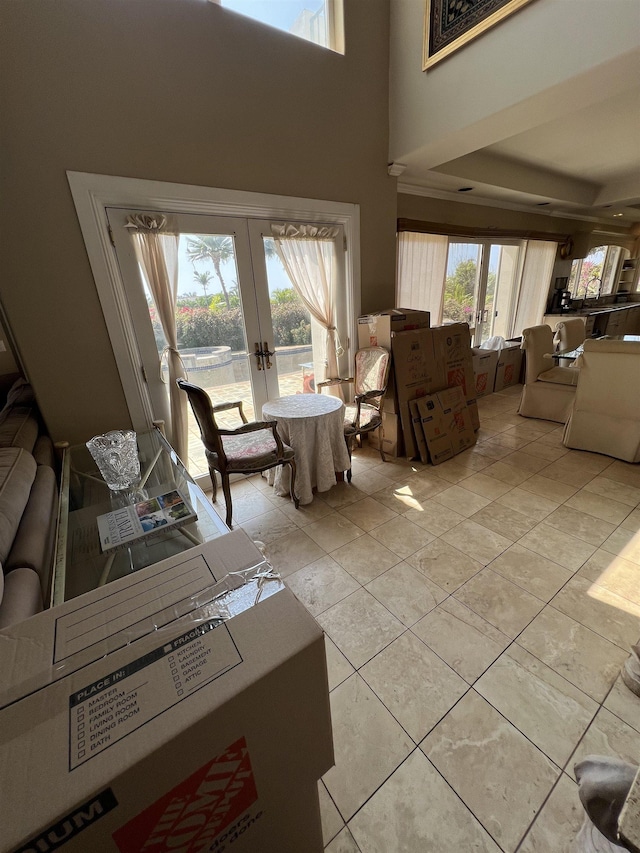 living area featuring a high ceiling, light tile patterned floors, and french doors