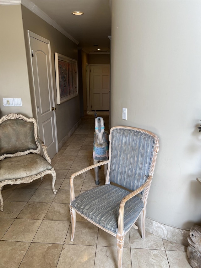 living area with tile patterned flooring, baseboards, and ornamental molding