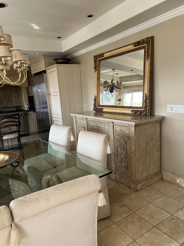 living area featuring light tile patterned floors, a notable chandelier, crown molding, and baseboards