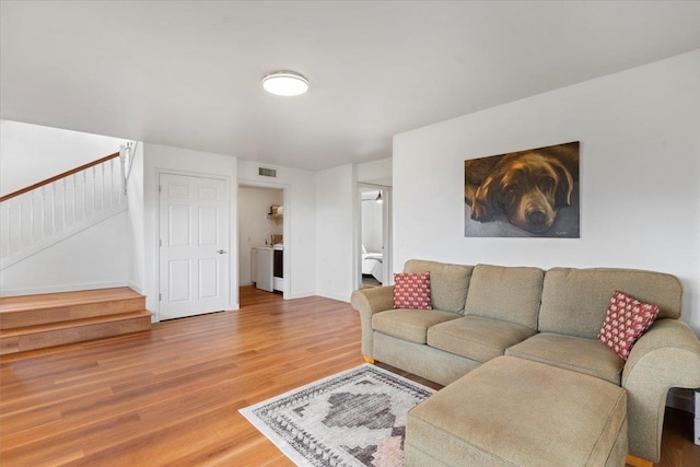 living room featuring wood-type flooring and washer / dryer