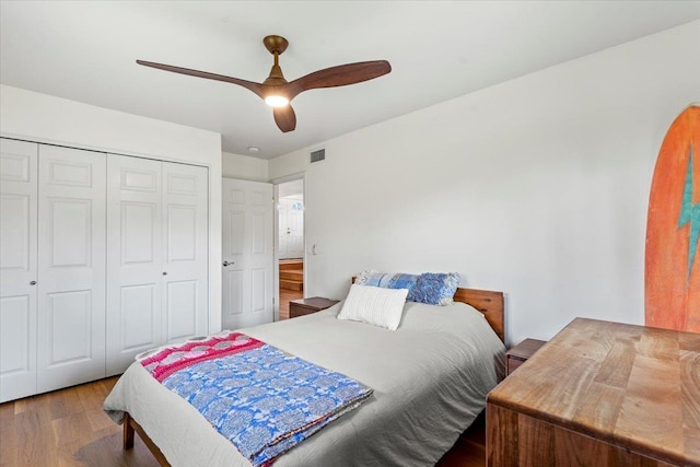 bedroom with ceiling fan, a closet, and hardwood / wood-style flooring