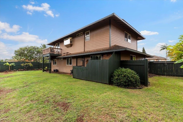 rear view of house featuring a balcony and a lawn