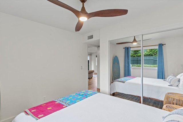 bedroom featuring ceiling fan, a closet, and hardwood / wood-style flooring