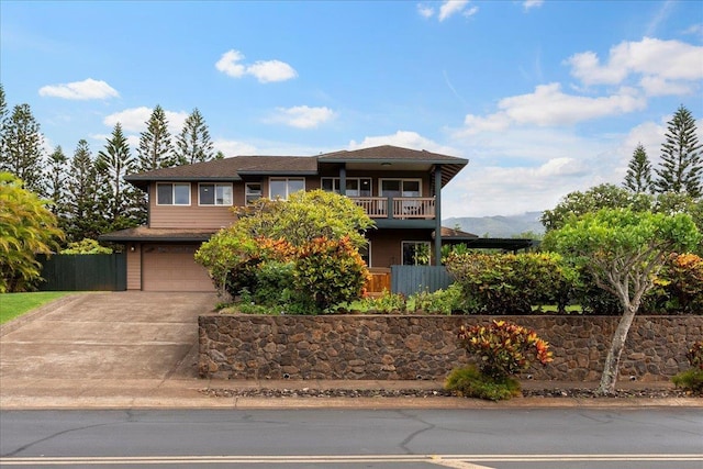 view of front facade featuring a mountain view, a garage, and a balcony