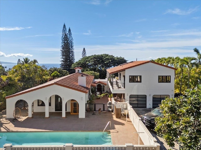 back of property with a patio and a fenced in pool