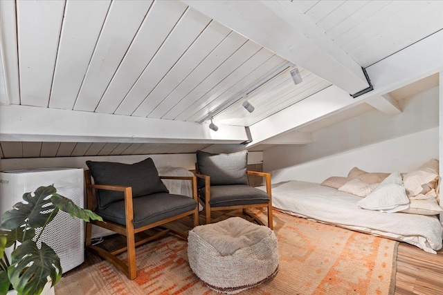 living area featuring beamed ceiling and wood-type flooring