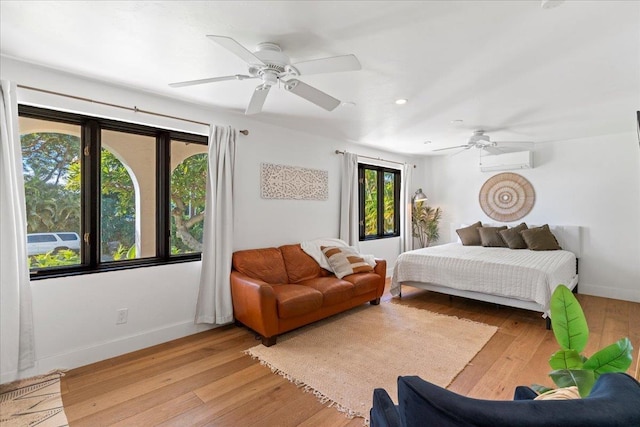 bedroom featuring a wall mounted air conditioner, ceiling fan, light hardwood / wood-style floors, and multiple windows