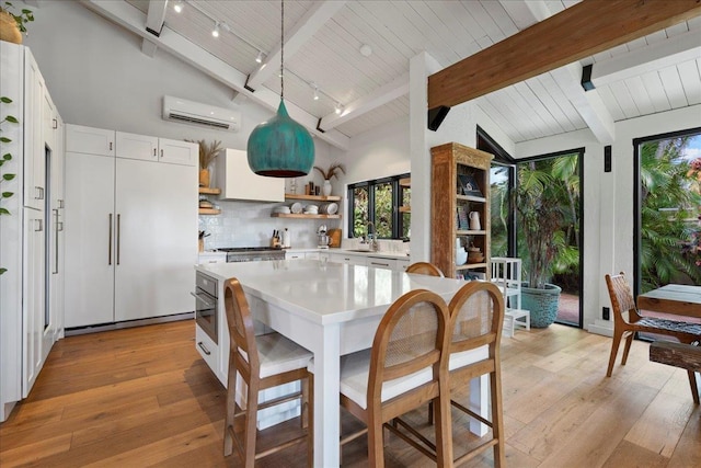 3291 Waileia Pl, Kihei, HI 96753 - kitchen featuring open shelves, a wall mounted AC, light countertops, backsplash, and light wood-style flooring