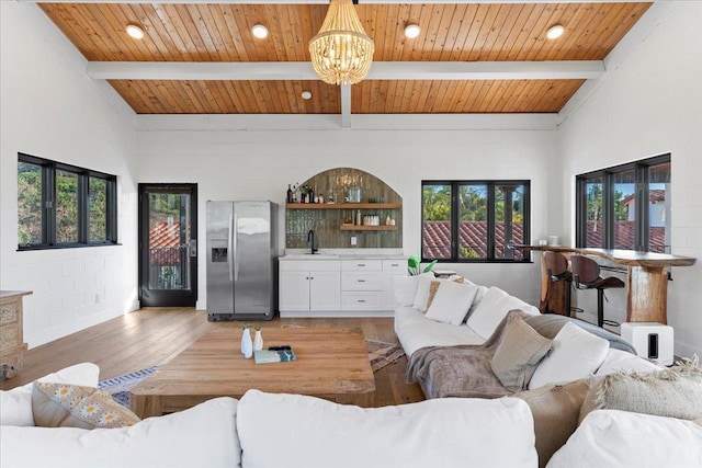 living room with hardwood / wood-style floors, beamed ceiling, and a healthy amount of sunlight