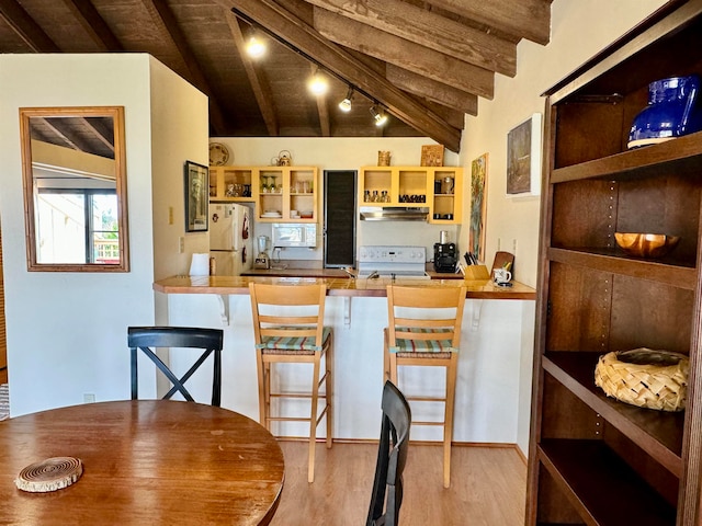 kitchen with lofted ceiling with beams, wood-type flooring, white appliances, and track lighting