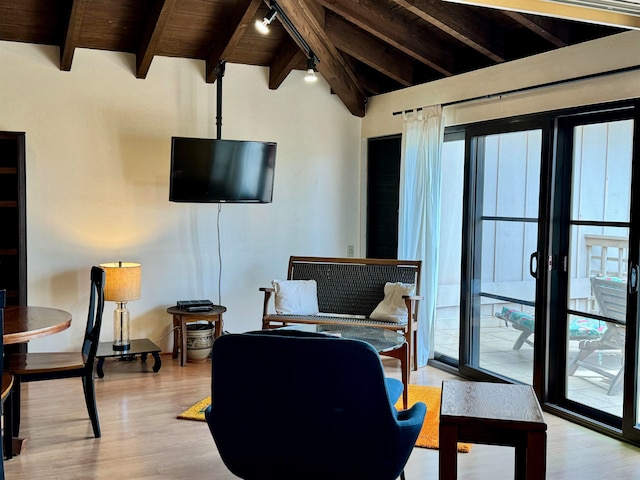 living room with rail lighting, light hardwood / wood-style flooring, vaulted ceiling with beams, and wood ceiling