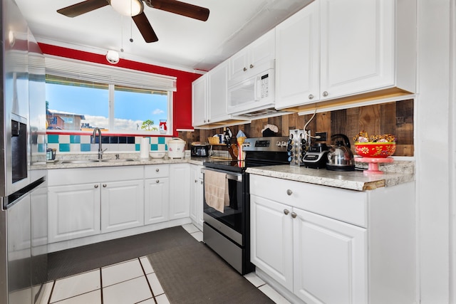 kitchen with electric range, sink, white cabinets, and tile patterned flooring