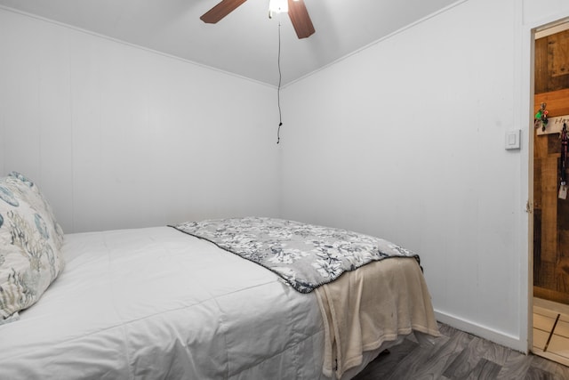 bedroom featuring hardwood / wood-style flooring, ceiling fan, and wood walls