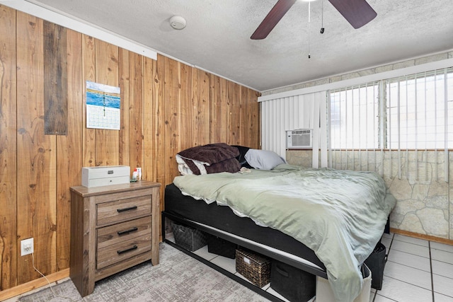 tiled bedroom featuring ceiling fan, wood walls, a textured ceiling, and cooling unit