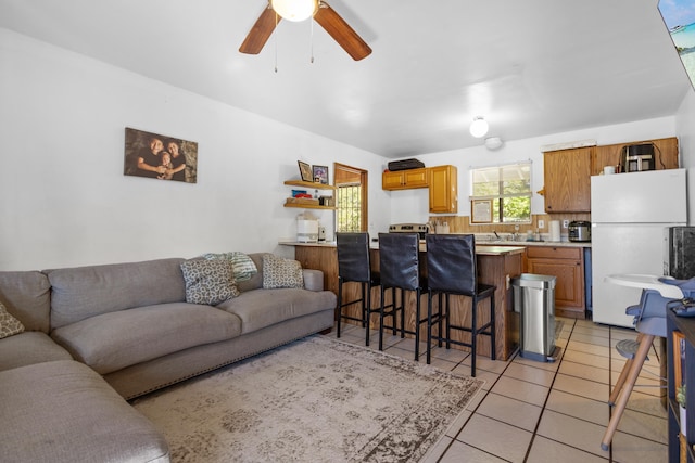 living room with light tile patterned floors, ceiling fan, and sink