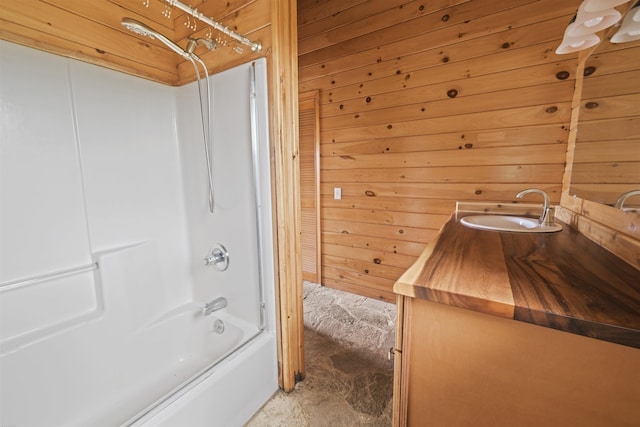 bathroom featuring wood walls,  shower combination, and vanity