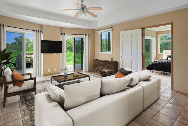 living room featuring ceiling fan and a tray ceiling