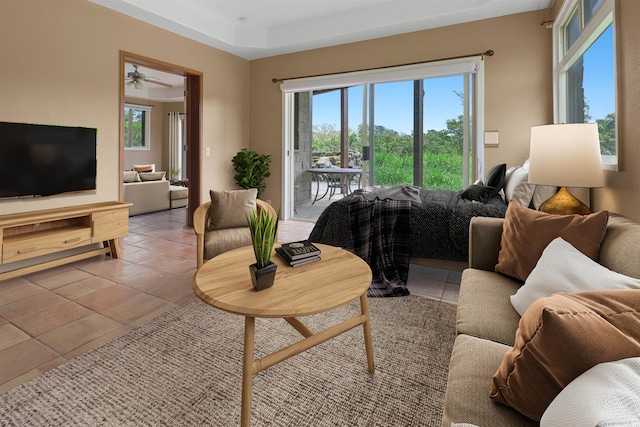 living room with ceiling fan, plenty of natural light, and light tile patterned floors