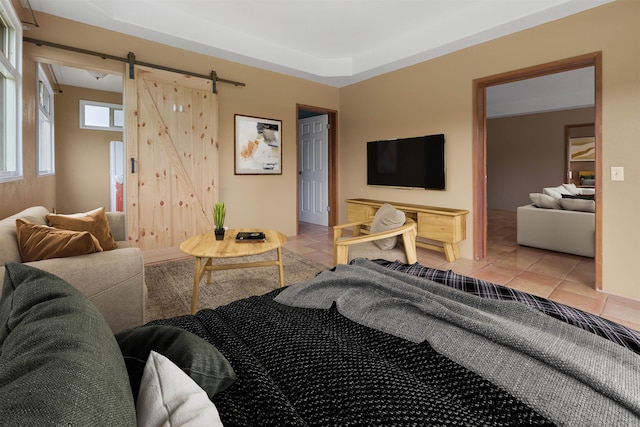 bedroom featuring a barn door and light tile patterned flooring