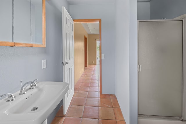 bathroom with tile patterned flooring, sink, and an enclosed shower