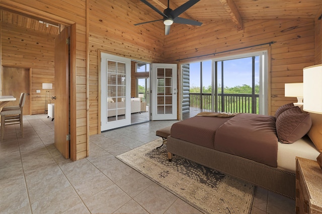 bedroom with wood walls, light tile patterned floors, beamed ceiling, access to exterior, and ceiling fan