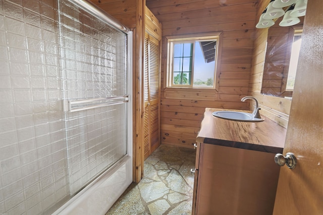 bathroom with enclosed tub / shower combo, wood ceiling, wood walls, and vanity