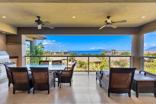 view of terrace with a grill, ceiling fan, a water view, and a balcony