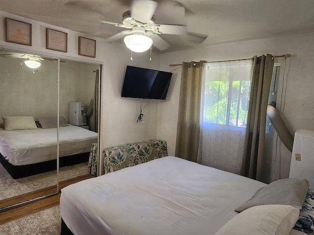 bedroom featuring ceiling fan, a closet, and wood finished floors