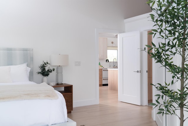 bedroom with baseboards and light wood finished floors