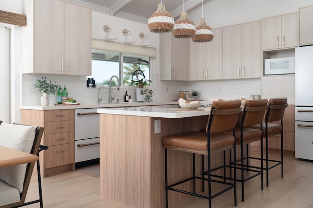 kitchen featuring backsplash, a kitchen breakfast bar, a kitchen island, and light countertops