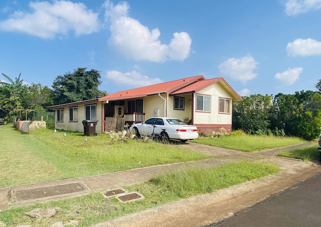 ranch-style house with metal roof and a front yard