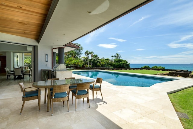 view of pool featuring a patio, a water view, and a grill