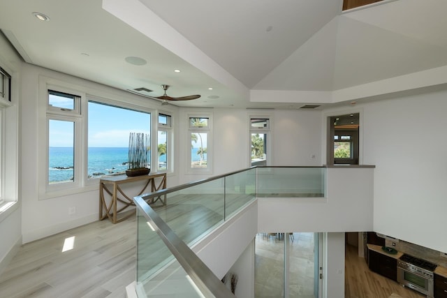 hallway featuring light hardwood / wood-style flooring and a water view