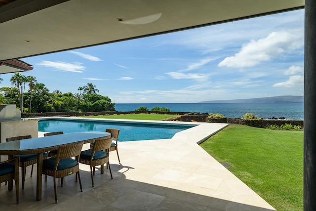 view of swimming pool featuring a patio, a lawn, and a water view