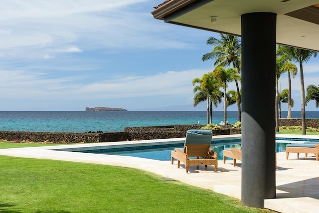 view of swimming pool with a patio area, a yard, and a water view