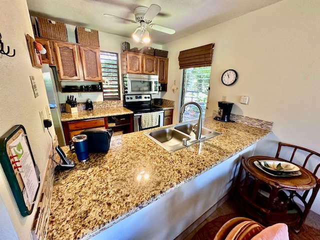 kitchen with stainless steel appliances, a healthy amount of sunlight, ceiling fan, and sink