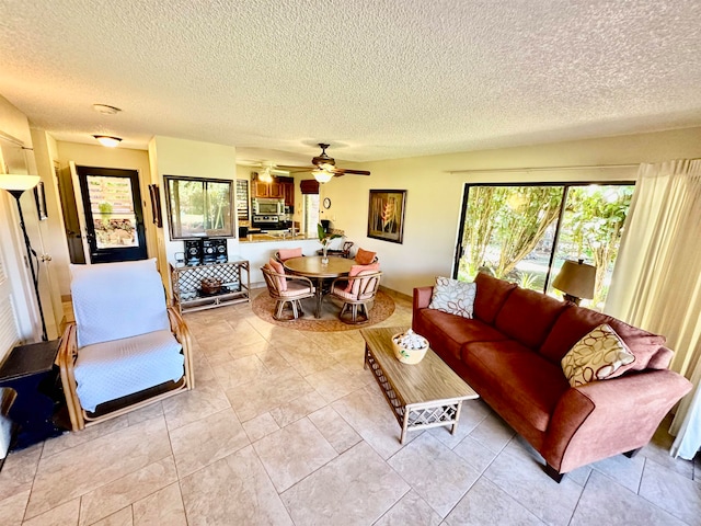 tiled living room with plenty of natural light, a textured ceiling, and ceiling fan