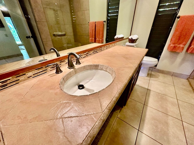 bathroom featuring vanity, tile floors, backsplash, and toilet