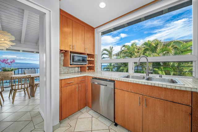 kitchen with decorative backsplash, sink, light tile patterned flooring, and stainless steel appliances