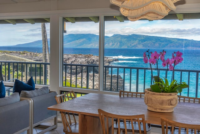 sunroom / solarium with a water and mountain view