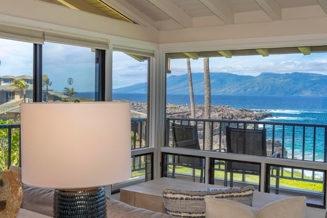 sunroom / solarium featuring vaulted ceiling with beams, a wealth of natural light, a water and mountain view, and wood ceiling