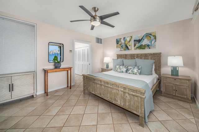 tiled bedroom with ceiling fan and a closet