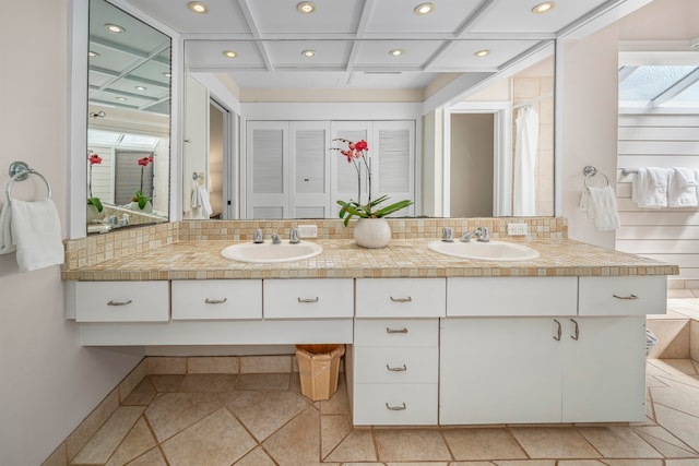 bathroom with decorative backsplash, vanity, a skylight, and coffered ceiling