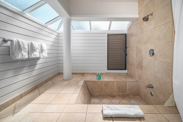 bathroom with a shower with shower curtain, wood walls, and tile patterned floors