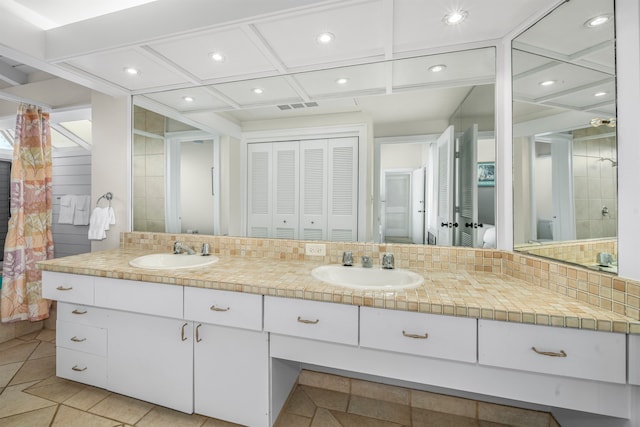 bathroom featuring tile patterned flooring, vanity, and backsplash