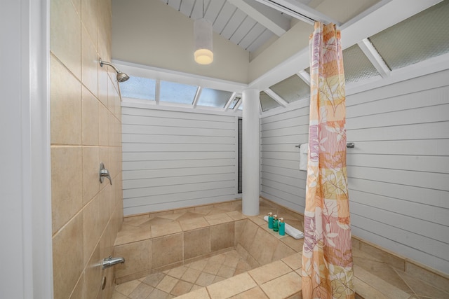 bathroom with tile patterned flooring, lofted ceiling with beams, wood walls, and walk in shower